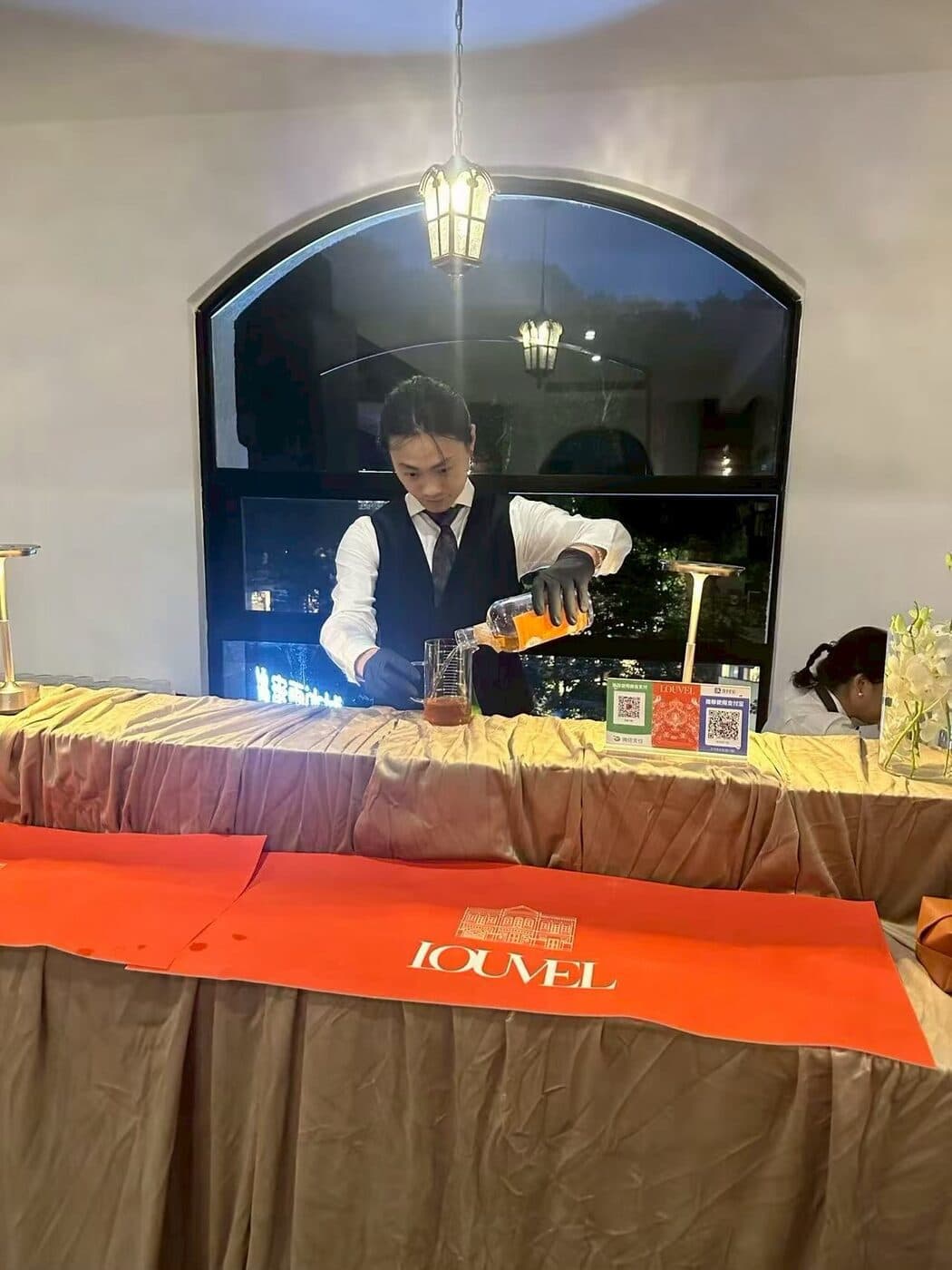 A bartender pouring LOUVEL brandy