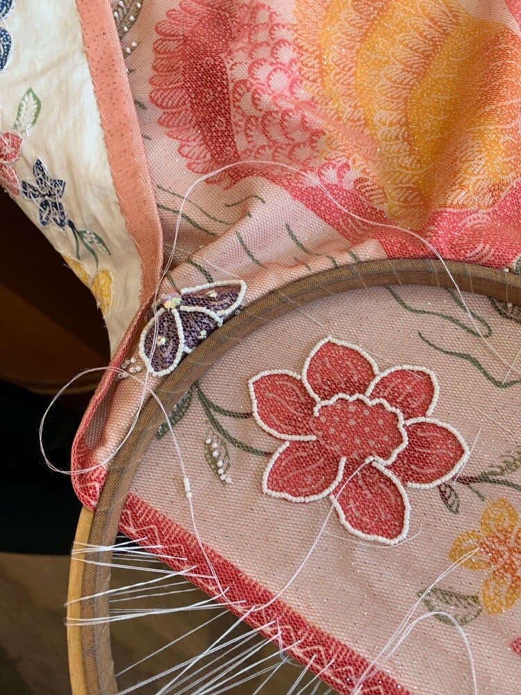 Hand embroidery in progress on a Peranakan beaded textile